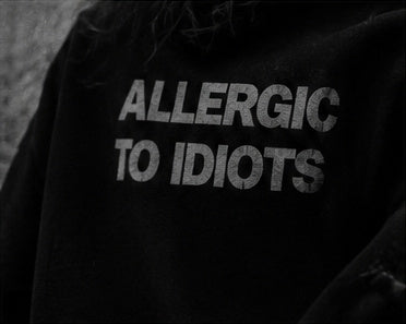 Black and white close-up of ALLERGIC TO IDIOTS lettering